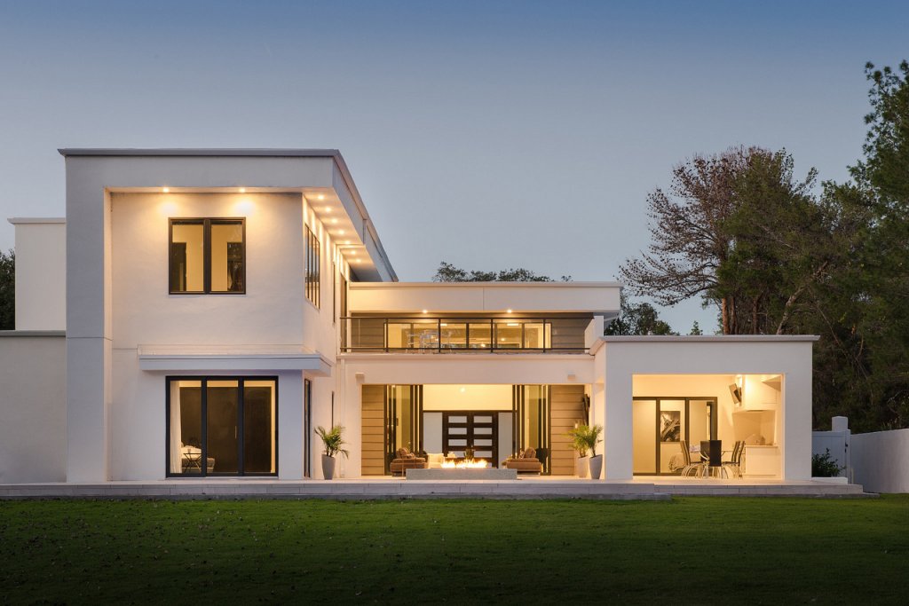 Back yard of a modern home glowing at dusk